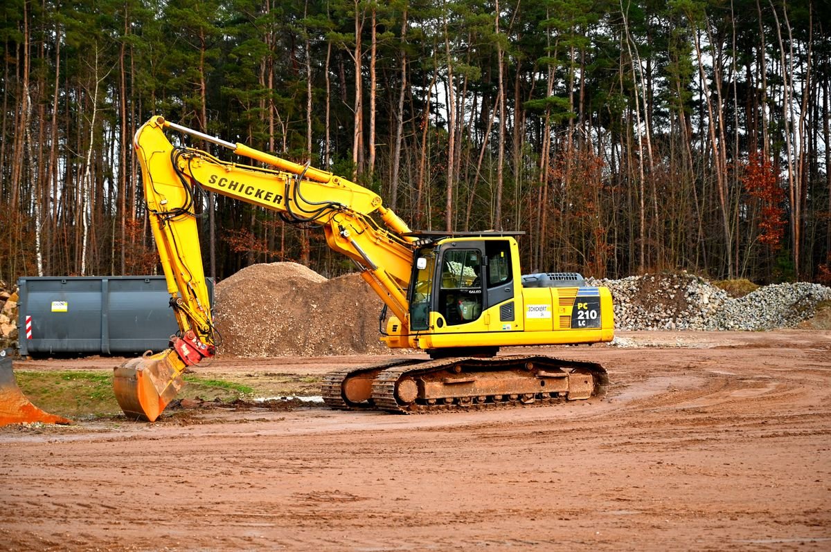 Hydraulic excavator with boom and arm cylinders at a work site